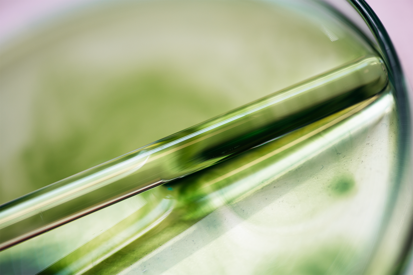 Tube en verre avec un liquide vert, photographié en gros plan sur un fond flou