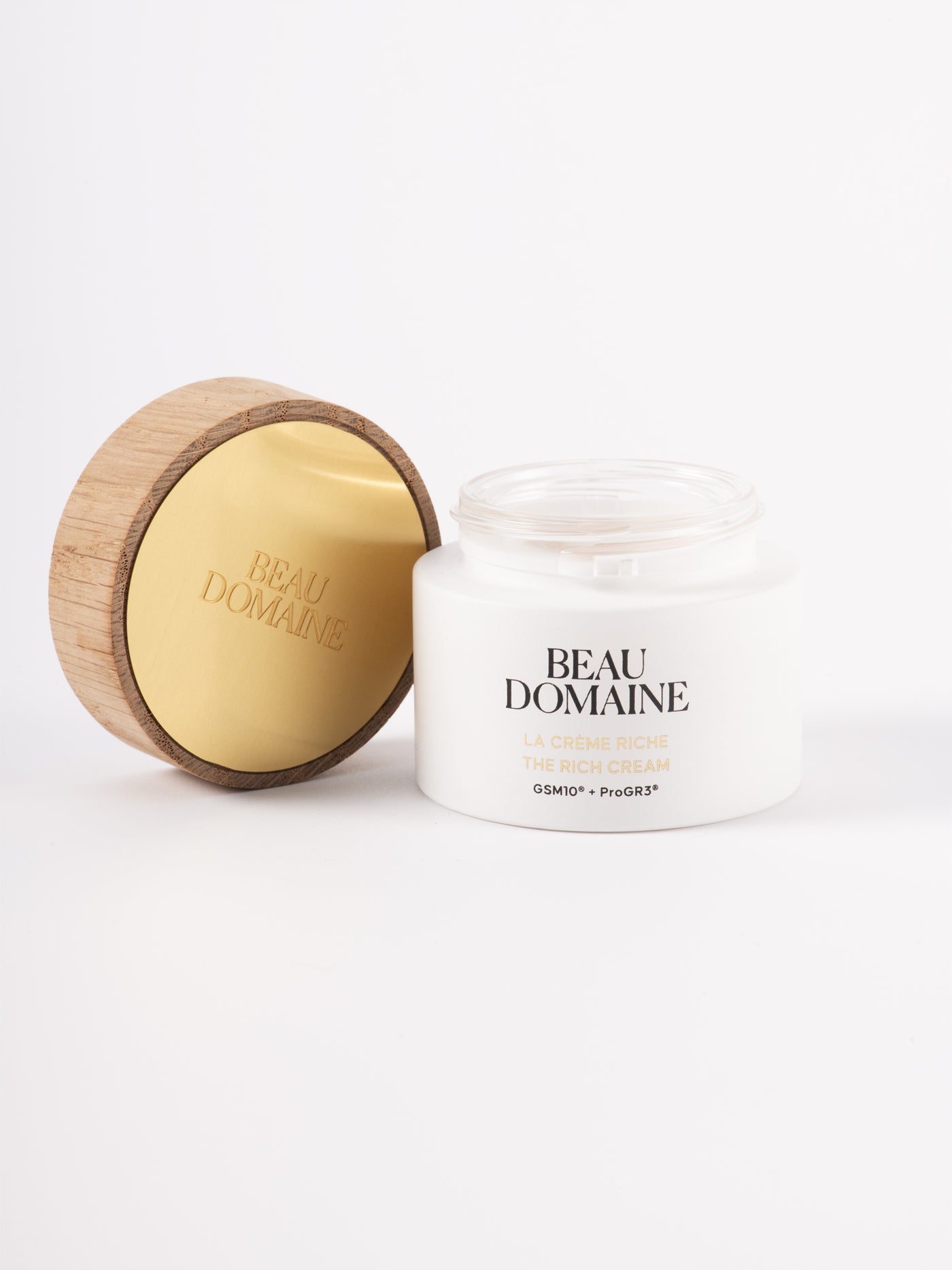 La crème riche sur un fond blanc et épuré, avec son capuchon ouvert posé à côté